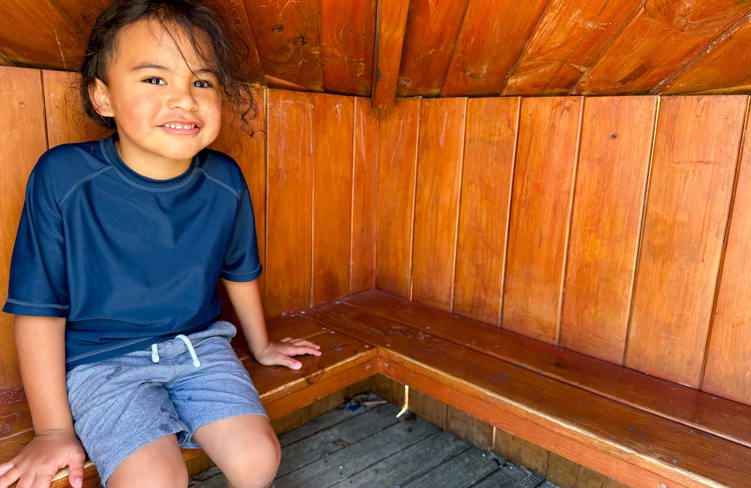 Evolve Education Preschool boy sitting in the whare at daycare